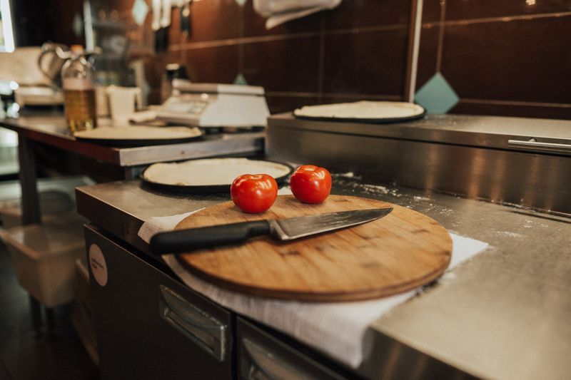 Salvatore Pizza kitchen preparing fresh pizza for delivery